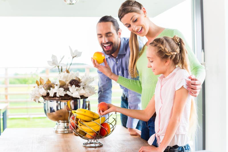 Familia que come las frutas frescas para la vida sana en cocina imagen de archivo libre de regalías Familia que come las frutas frescas para la vida sana en cocina imagen de archivo libre de regalías