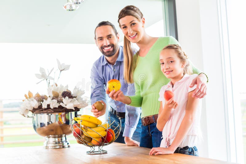 Familia que come las frutas frescas para la vida sana en cocina fotos de archivo libres de regalías Familia que come las frutas frescas para la vida sana en cocina fotos de archivo libres de regalías