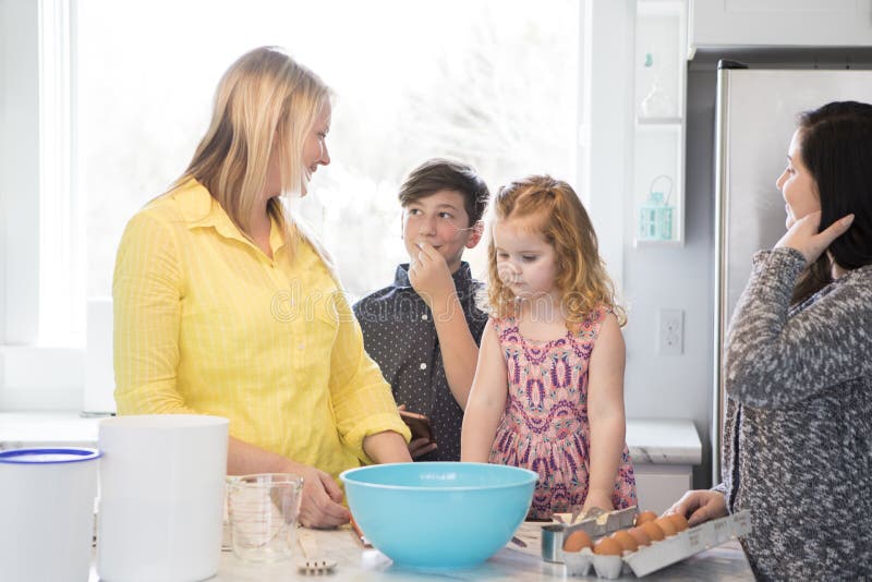 Familia que cuece junto en una cocina moderna fotografía de archivo Familia que cuece junto en una cocina moderna fotografía de archivo