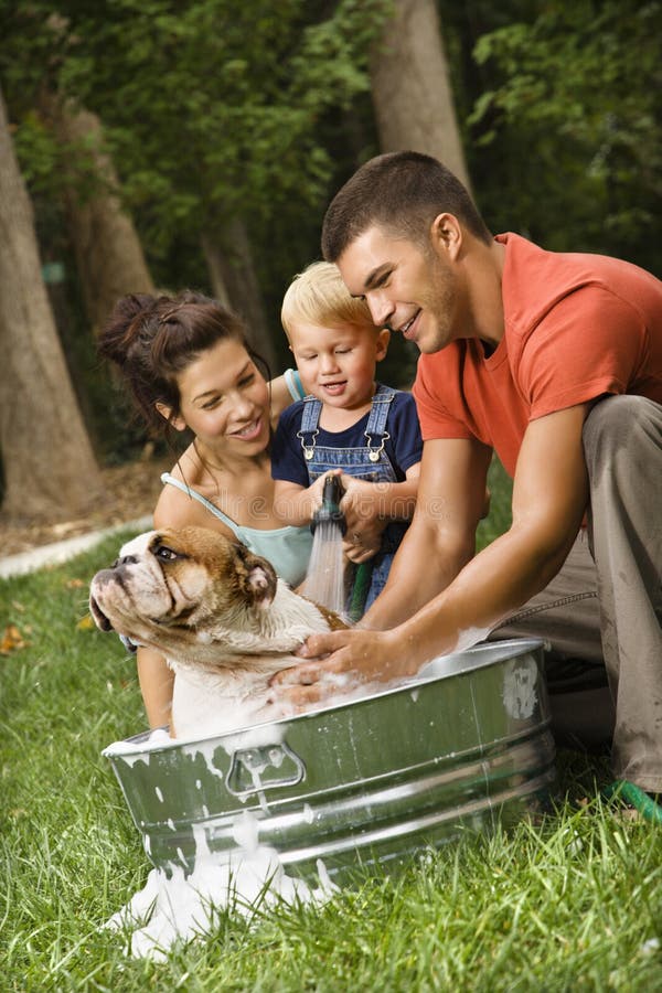 Familia que da a perro un baño. Familia que da a perro un baño.