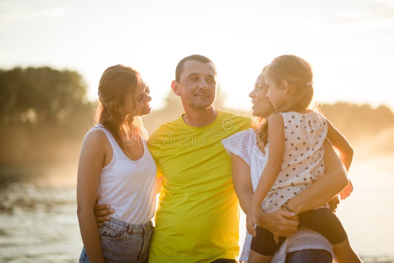 Familia que disfruta de un día de verano cerca del río Concepto del amor y de la vinculación fotografía de archivo libre de regalías Familia que disfruta de un día de verano cerca del río Concepto del amor y de la vinculación fotografía de archivo libre de regalías