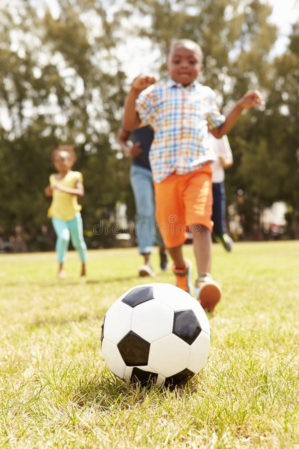 Familia que juega al fútbol en parque junto fotografía de archivo Familia que juega al fútbol en parque junto fotografía de archivo