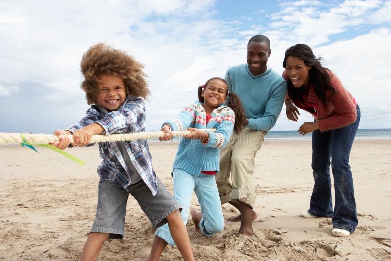 Familia que juega esfuerzo supremo en la playa foto de archivo