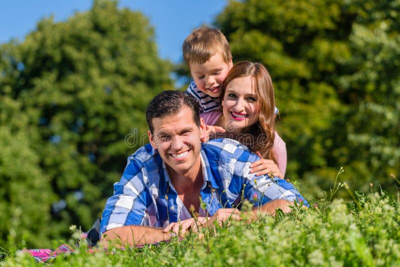 Familia que miente en hierba encima de uno a foto de archivo Familia que miente en hierba encima de uno a foto de archivo