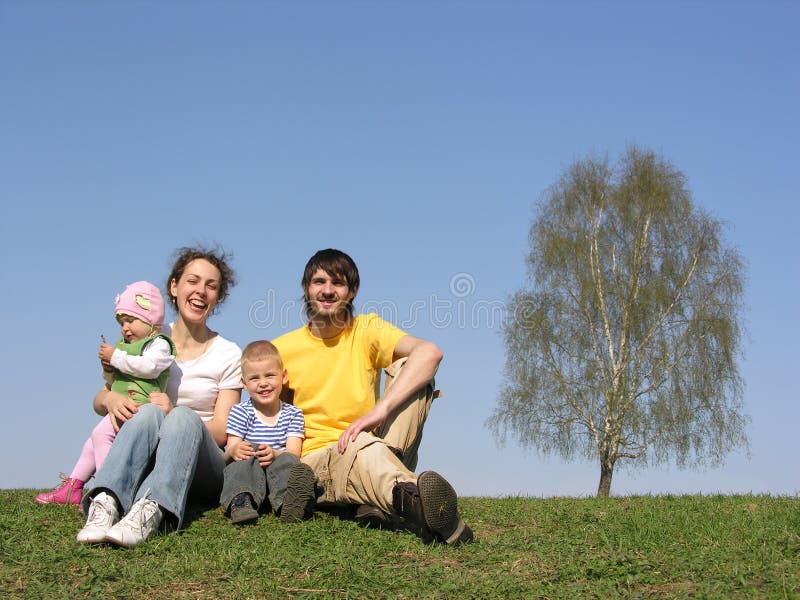 Familia que se sienta con dos niños. resorte. fotografía de archivo libre de regalías Familia que se sienta con dos niños. resorte. fotografía de archivo libre de regalías