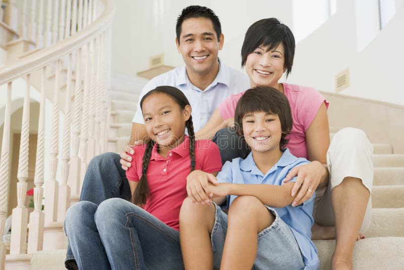 Familia que se sienta en la sonrisa de la escalera imágenes de archivo libres de regalías Familia que se sienta en la sonrisa de la escalera imágenes de archivo libres de regalías
