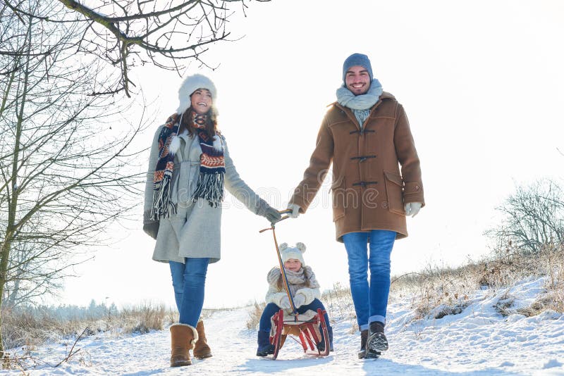 Familia que toma un paseo del invierno en la nieve foto de archivo libre de regalías Familia que toma un paseo del invierno en la nieve foto de archivo libre de regalías