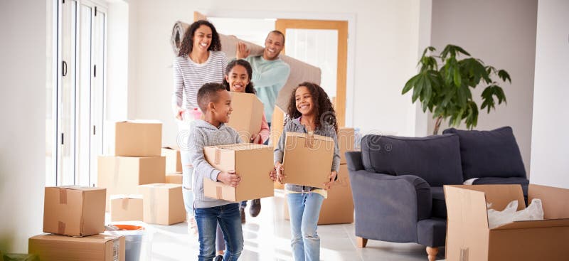 Smiling Family Carrying Boxes Into New Home On Moving Day. Smiling Family Carrying Boxes Into New Home On Moving Day