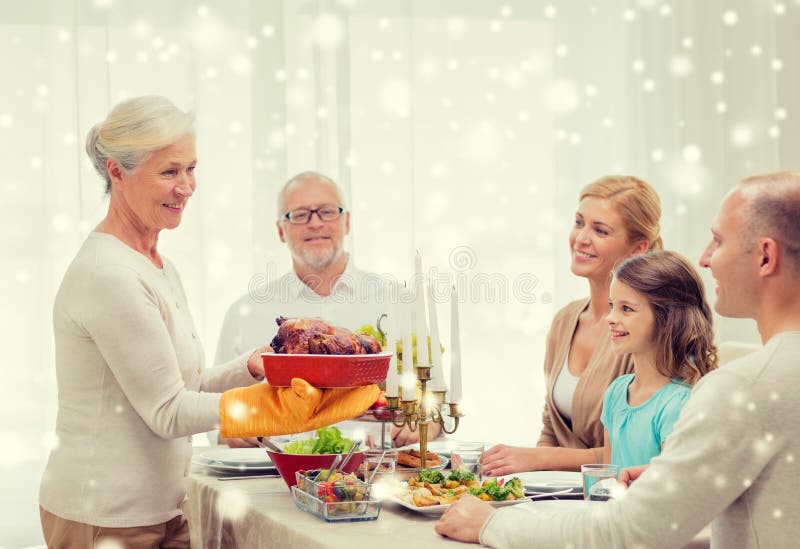Family, holidays, generation, christmas and people concept - smiling family having dinner at home. Family, holidays, generation, christmas and people concept - smiling family having dinner at home