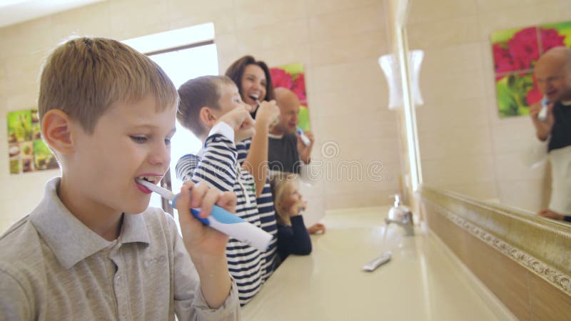 Familia spălându-și dinții în baie stock video