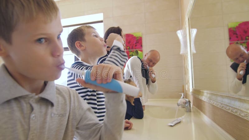 Familia spălându-și dinții în baie stock video
