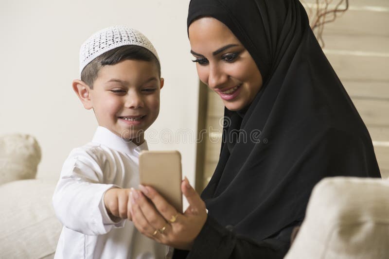 Familia árabe, madre árabe e hijo que usa el teléfono móvil foto de archivo Familia árabe, madre árabe e hijo que usa el teléfono móvil foto de archivo