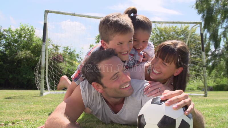 Familie care joacă fotbal în grădină împreună stock video footage