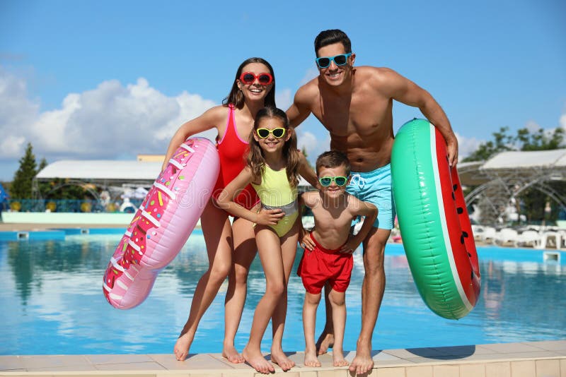 Familie cu inele gonflabile în apropierea piscinei. vacanță de vară stock photos