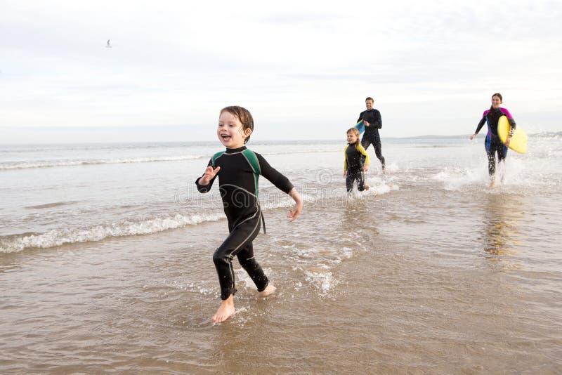 Familie in den Wetsuits stockbild Familie in den Wetsuits stockbild