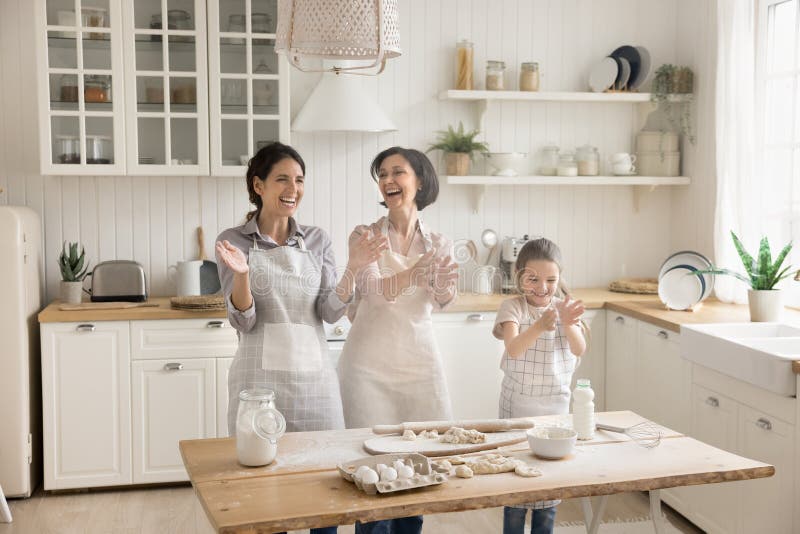 Familie der drei Generationen, die beim Teigmachen mit Mehl spielt stockfoto