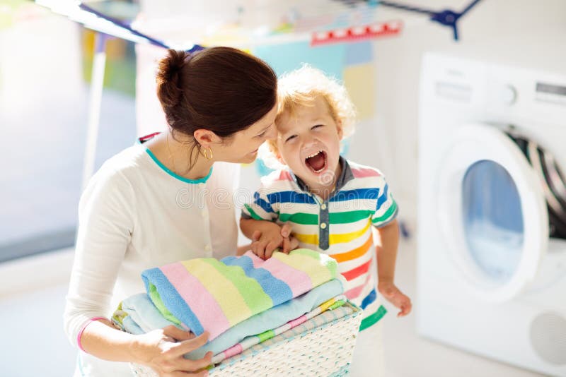 Familie in der Waschk?che mit Waschmaschine lizenzfreie stockfotografie Familie in der Waschk?che mit Waschmaschine lizenzfreie stockfotografie