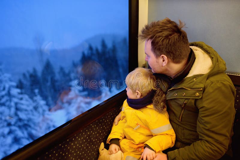 Familie, die aus dem Fenster des Zugs heraus während der Reise auf Zahnradeisenbahn/-Zahnradbahn in den Alpenbergen schaut stockbild Familie, die aus dem Fenster des Zugs heraus während der Reise auf Zahnradeisenbahn/-Zahnradbahn in den Alpenbergen schaut stockbild