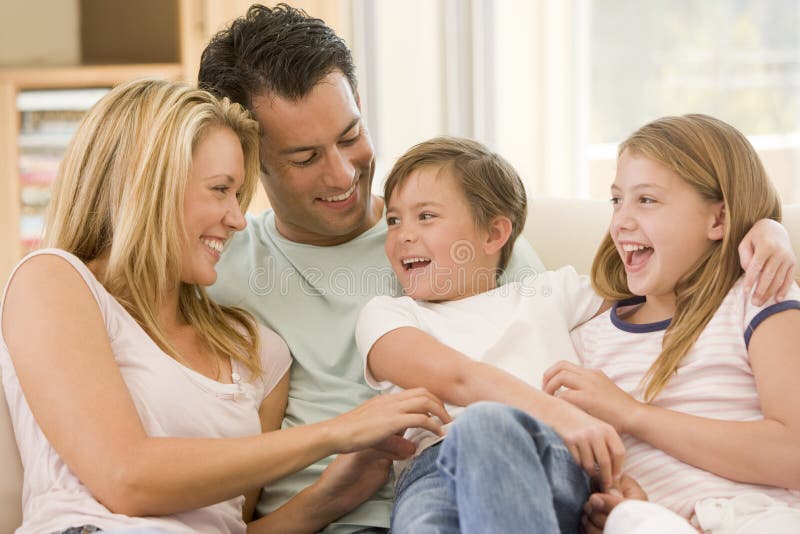 Familie, die beim Wohnzimmerlächeln sitzt stockbilder Familie, die beim Wohnzimmerlächeln sitzt stockbilder