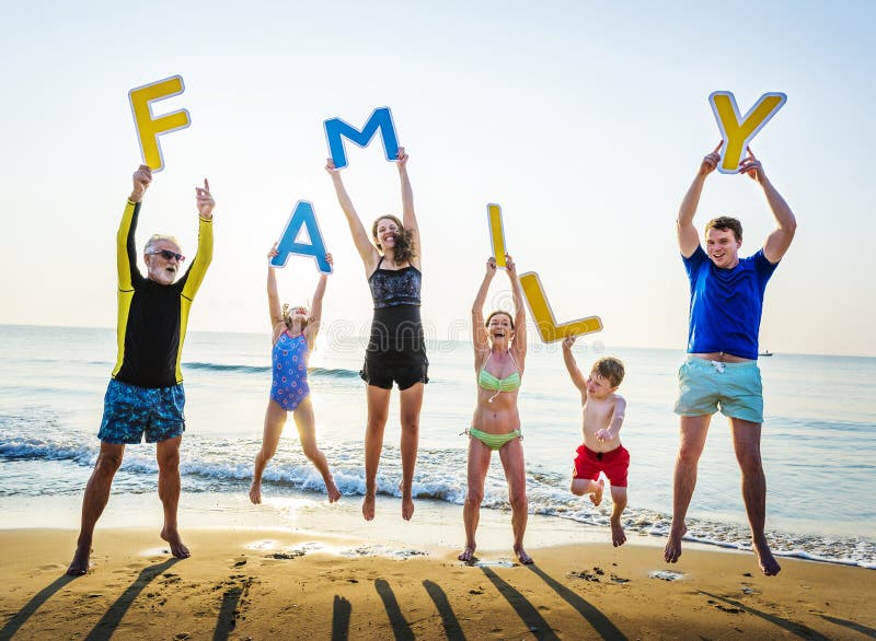 Familie, die Buchstaben am Strand hält stockbilder Familie, die Buchstaben am Strand hält stockbilder