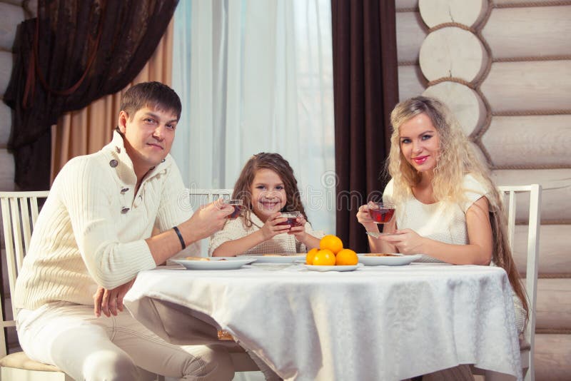 Familie die diner bij een eettafel, Rondetafel, pizza, sinaasappel, huis eten dat van hout wordt gemaakt royalty-vrije stock foto Familie die diner bij een eettafel, Rondetafel, pizza, sinaasappel, huis eten dat van hout wordt gemaakt royalty-vrije stock foto