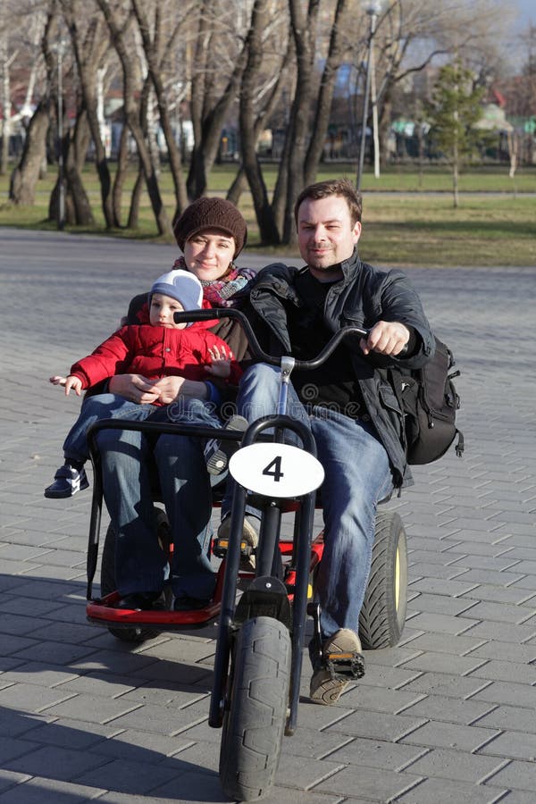 Familie, die drei fahrbares Fahrrad fährt stockfotografie Familie, die drei fahrbares Fahrrad fährt stockfotografie