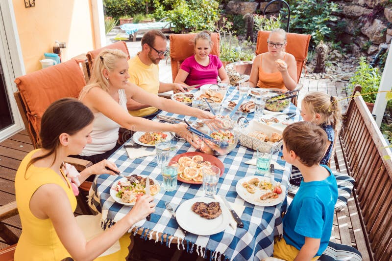 Familie, die ein Gartenfest isst am Tisch hat stockfotos Familie, die ein Gartenfest isst am Tisch hat stockfotos