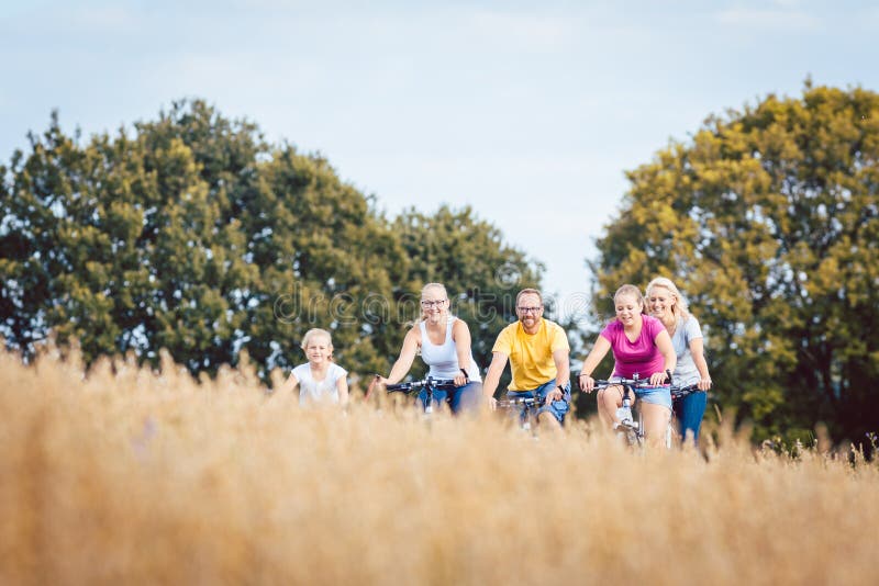 Familie die hun die fietsen berijden boven een korrelgebied worden geschoten royalty-vrije stock foto Familie die hun die fietsen berijden boven een korrelgebied worden geschoten royalty-vrije stock foto