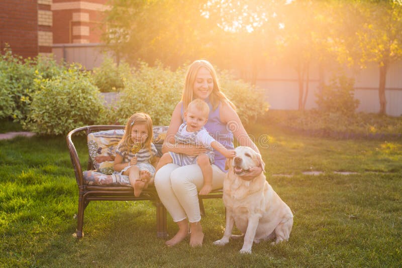 Familie, die im Garten mit Schoßhund sich entspannt lizenzfreies stockfoto Familie, die im Garten mit Schoßhund sich entspannt lizenzfreies stockfoto