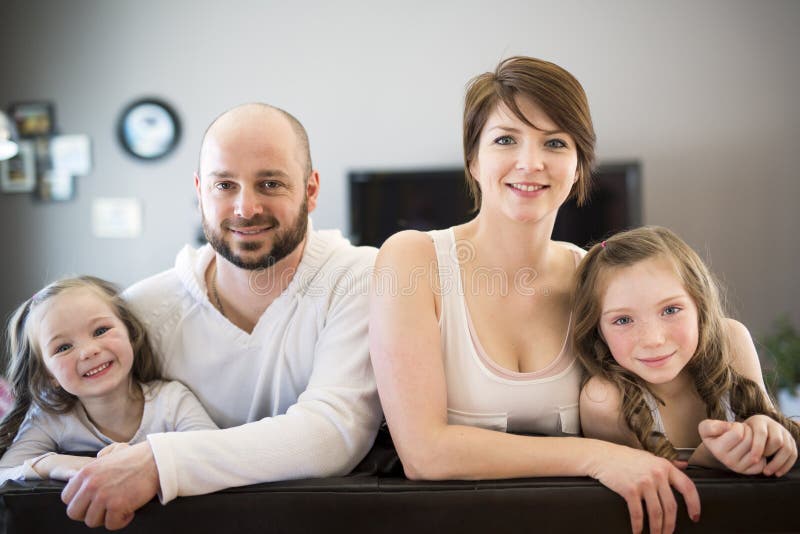 Familie, die im Wohnzimmer fernsieht sitzt lizenzfreies stockfoto Familie, die im Wohnzimmer fernsieht sitzt lizenzfreies stockfoto