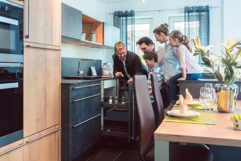 Familie die met jonge geitjes een keuken in toonzaal bekijken royalty-vrije stock afbeeldingen Familie die met jonge geitjes een keuken in toonzaal bekijken royalty-vrije stock afbeeldingen