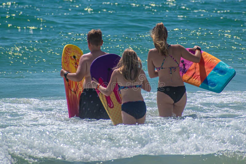 Daytona Beach Florida. July 07, 2019 Family with surfboard enjoying waves 3. Daytona Beach Florida. July 07, 2019 Family with surfboard enjoying waves 3