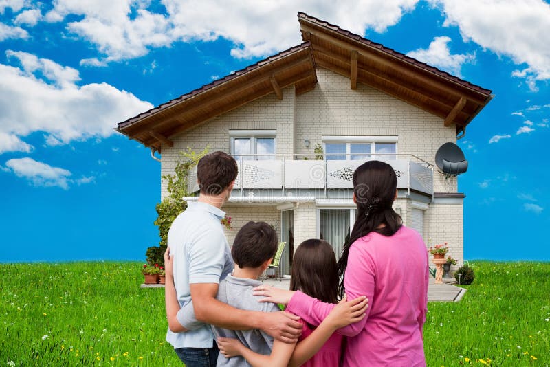 Familie, die neues Haus auf grasartigem Feld betrachtet lizenzfreie stockbilder Familie, die neues Haus auf grasartigem Feld betrachtet lizenzfreie stockbilder