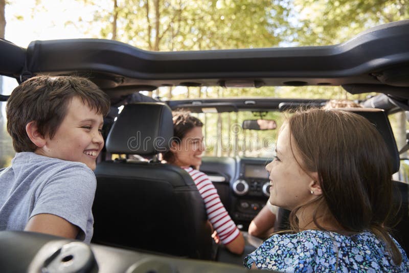 Familie, die in offenes Auto auf Landschafts-Autoreise fährt lizenzfreie stockfotos Familie, die in offenes Auto auf Landschafts-Autoreise fährt lizenzfreie stockfotos