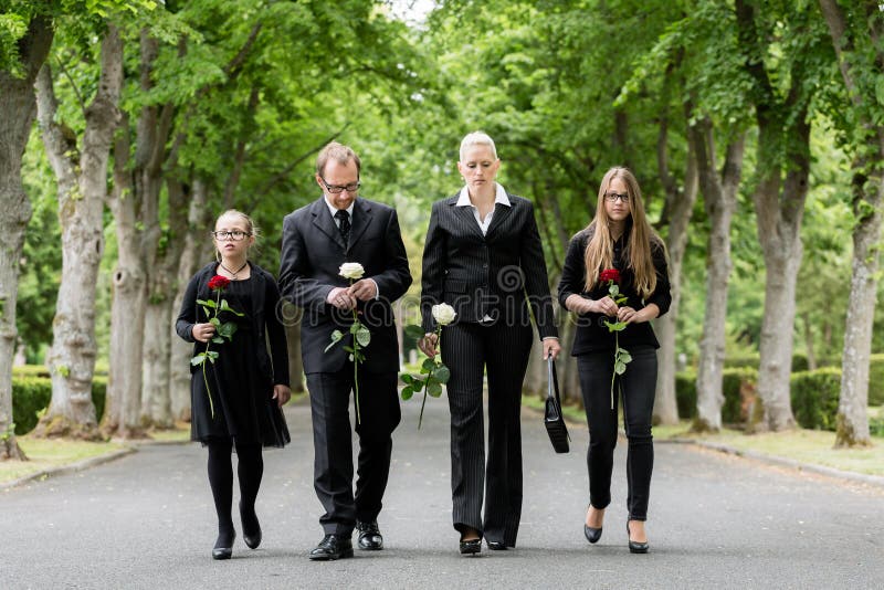 Familie die onderaan steeg bij kerkhof lopen stock fotografie Familie die onderaan steeg bij kerkhof lopen stock fotografie