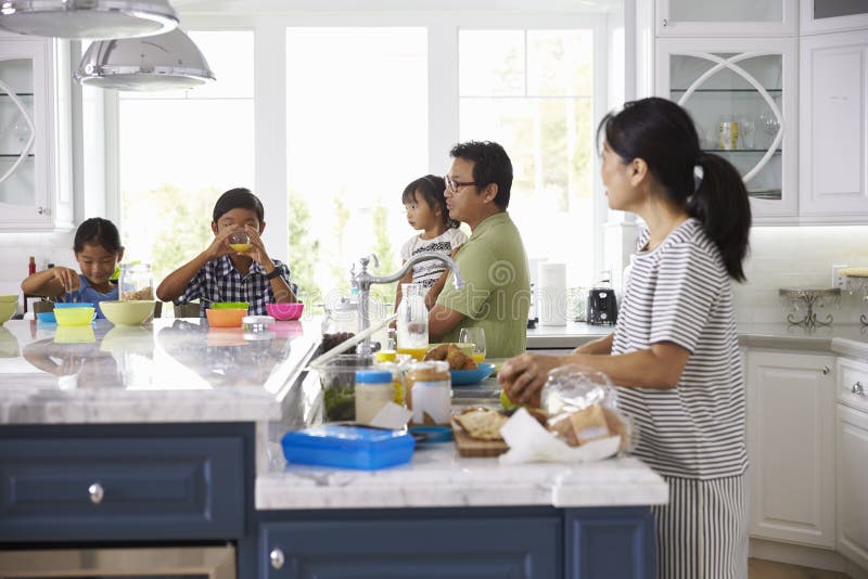 Familie die Ontbijt hebben en Lunchen in Keuken maken stock afbeeldingen Familie die Ontbijt hebben en Lunchen in Keuken maken stock afbeeldingen