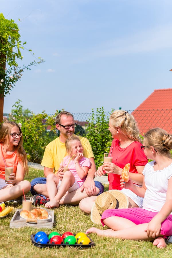 Familie, die Picknick in der Gartenfront ihres Hauses hat lizenzfreie stockfotos Familie, die Picknick in der Gartenfront ihres Hauses hat lizenzfreie stockfotos