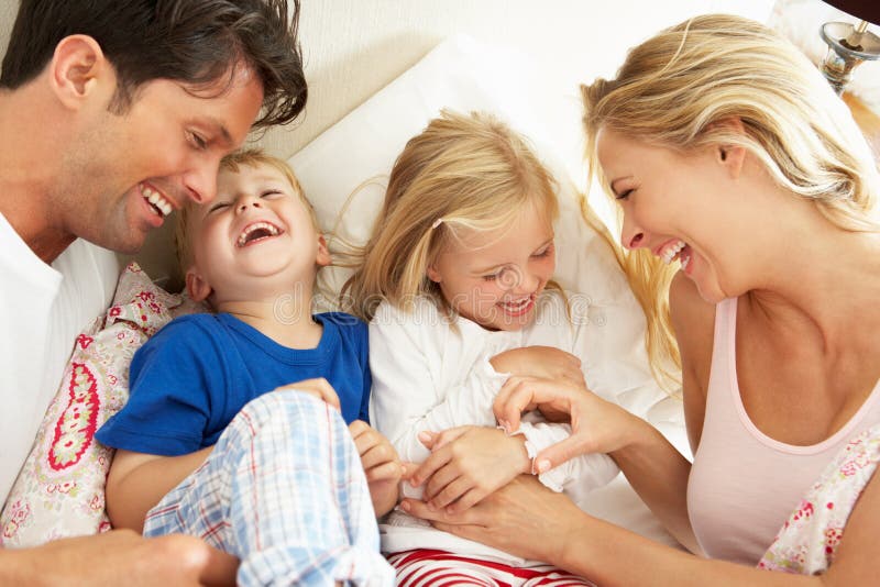 Familie, die sich zusammen im Bett entspannt lizenzfreies stockbild Familie, die sich zusammen im Bett entspannt lizenzfreies stockbild