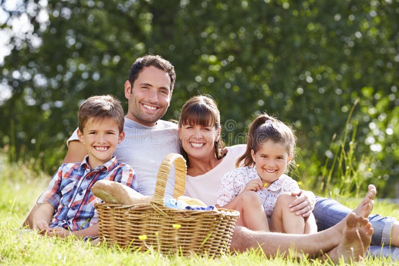 Familie, die Sommer-Picknick in der Landschaft genießt lizenzfreie stockfotografie Familie, die Sommer-Picknick in der Landschaft genießt lizenzfreie stockfotografie