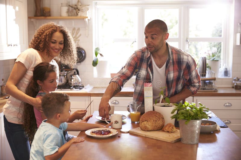 Familie die thuis Ontbijt in Keuken samen eten stock afbeelding Familie die thuis Ontbijt in Keuken samen eten stock afbeelding