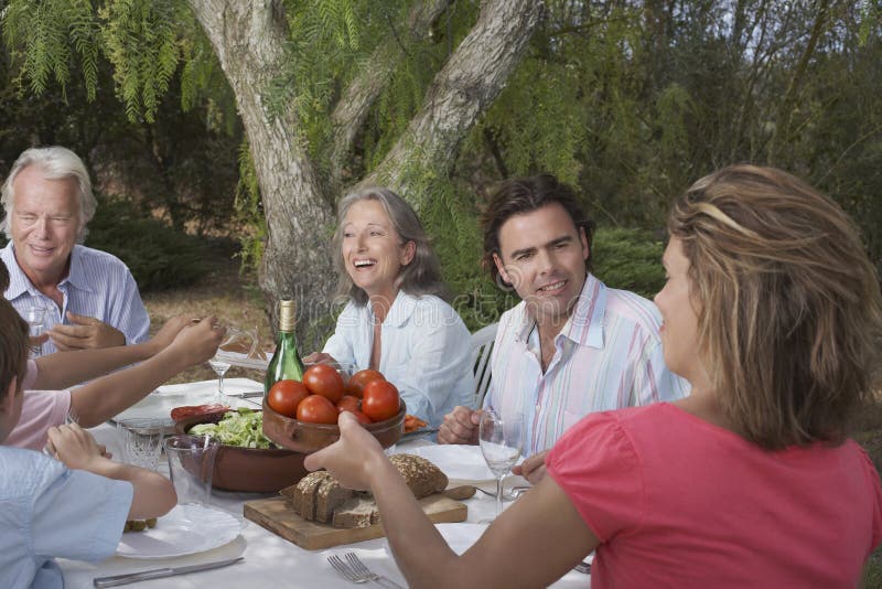 Familie die in Tuin dineren stock afbeelding