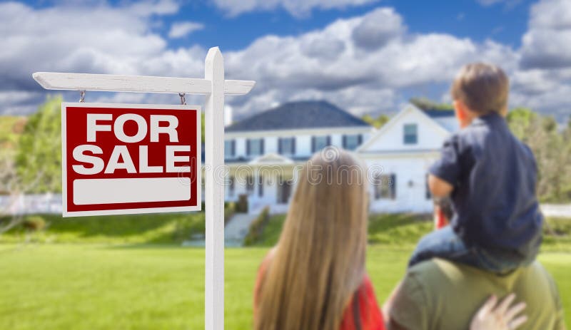 Familie die voor het Teken en het Huis van Verkoopreal estate onder ogen zien stock foto's Familie die voor het Teken en het Huis van Verkoopreal estate onder ogen zien stock foto's