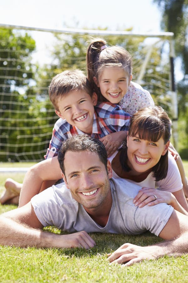Familie, die zusammen Fußball im Garten spielt lizenzfreie stockbilder Familie, die zusammen Fußball im Garten spielt lizenzfreie stockbilder