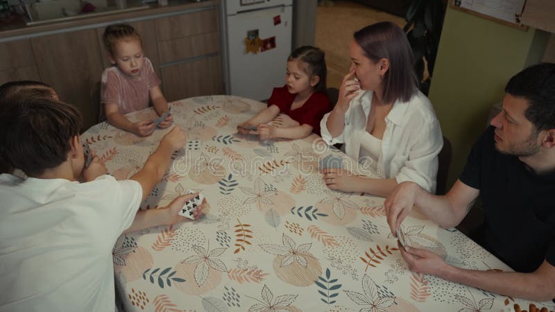 Familie fericită jucând cărți împreună la masa de bucătărie stock video footage