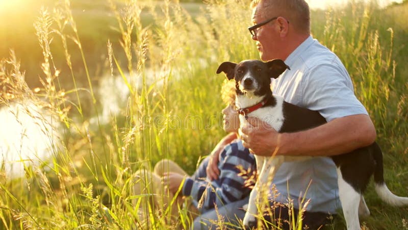 Familie, Generation, Kommunikation und Leutekonzept - Großvater und Enkel mit einem seinem Hund, der an sitzt und spricht