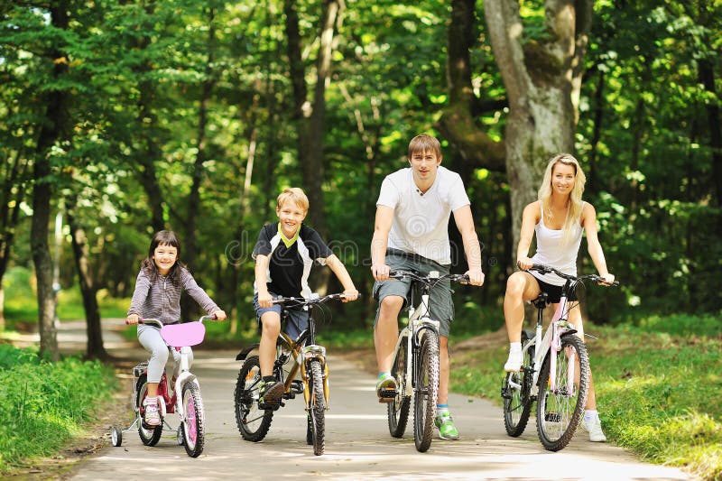 Happy family in the park on bicycles. Happy family in the park on bicycles