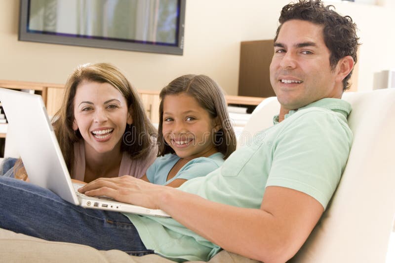 Familie im Wohnzimmer mit Laptop lizenzfreie stockfotografie Familie im Wohnzimmer mit Laptop lizenzfreie stockfotografie
