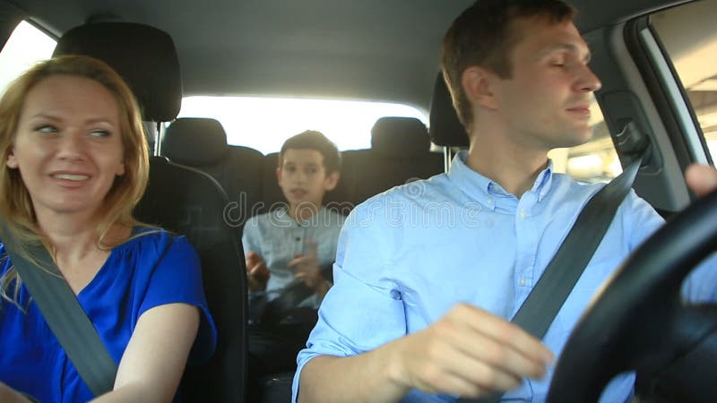Familie, mammapapa en zoon het berijden in auto, zingen zij liederen met de gehele familie