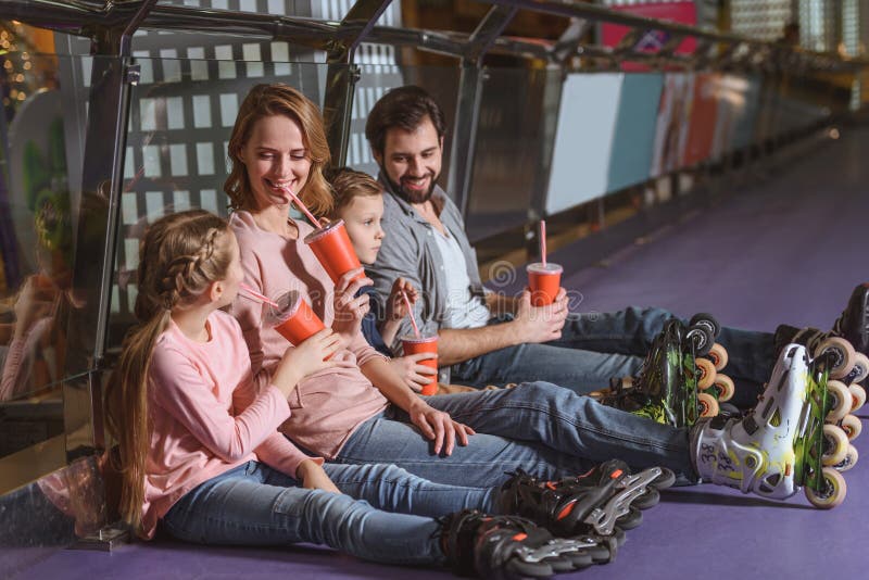 familie met dranken die na het schaatsen rusten royalty-vrije stock foto familie met dranken die na het schaatsen rusten royalty-vrije stock foto