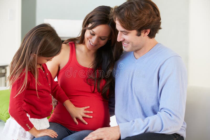 Familie met het Zwangere Moeder Ontspannen op Sofa Together stock afbeeldingen Familie met het Zwangere Moeder Ontspannen op Sofa Together stock afbeeldingen